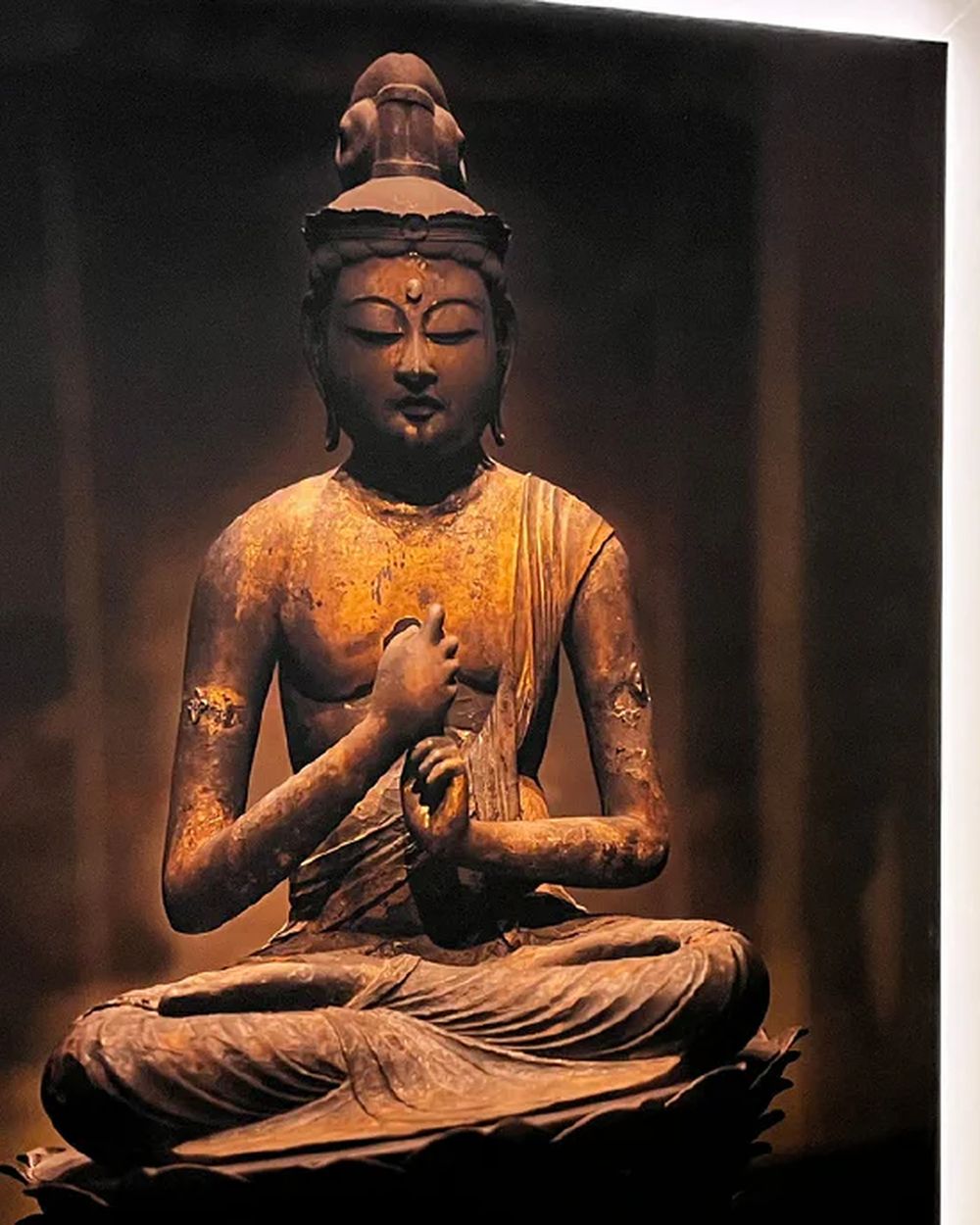 Vorraum des Saunabereichs mit beleuchtetem Buddha-Bild und Duschen